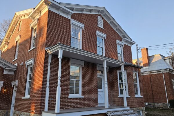 Maison en briques rouges avec porche blanc