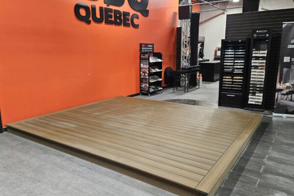 Échantillons de bois devant mur orange et présentoirs.