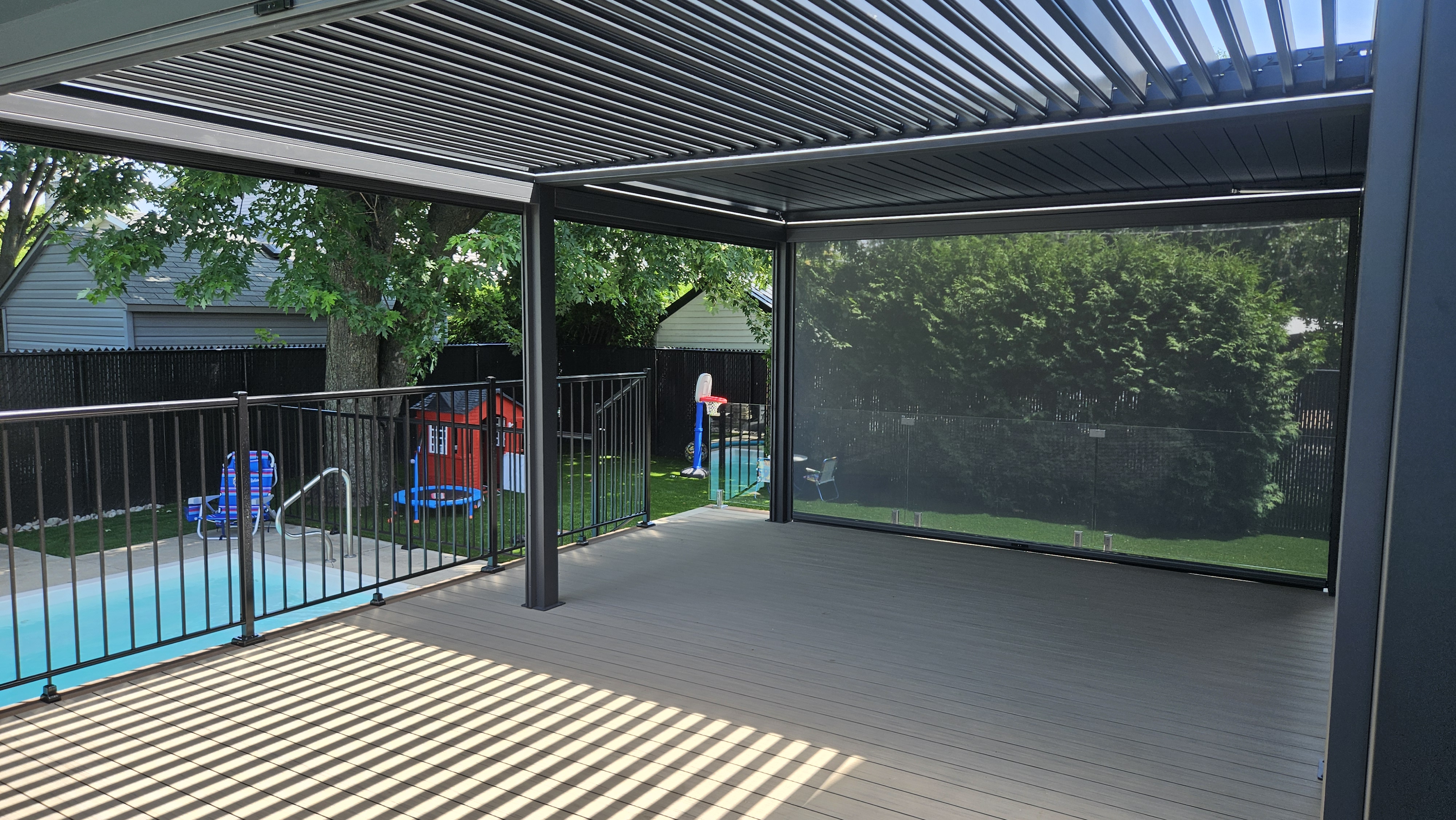 Pergola moderne avec vue sur piscine et jardin.