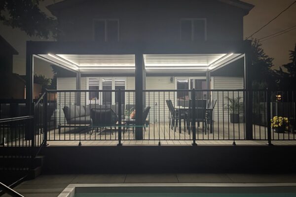 Patio éclairé la nuit avec piscine.