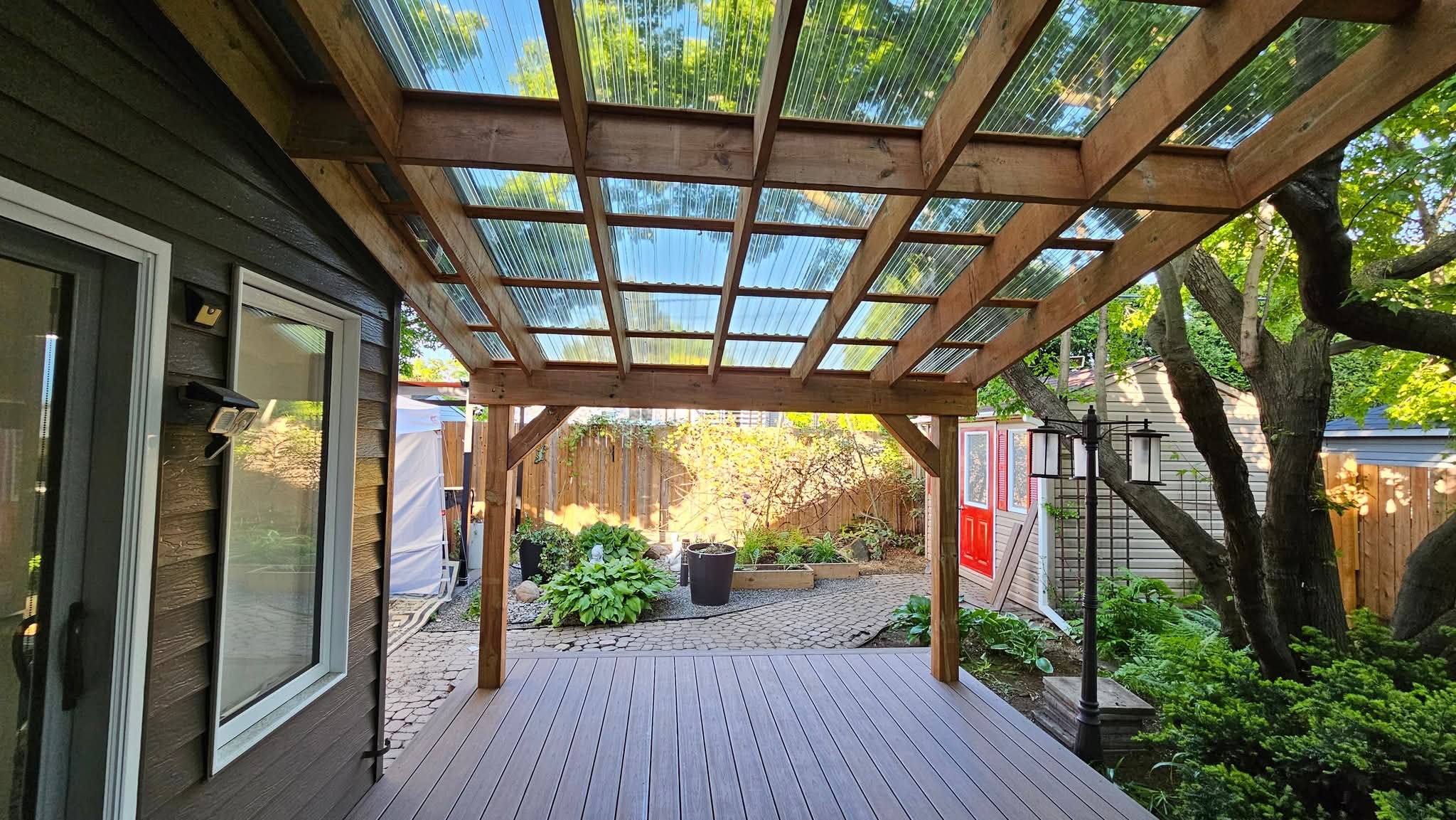 Terrasse couverte en bois avec vue sur jardin.