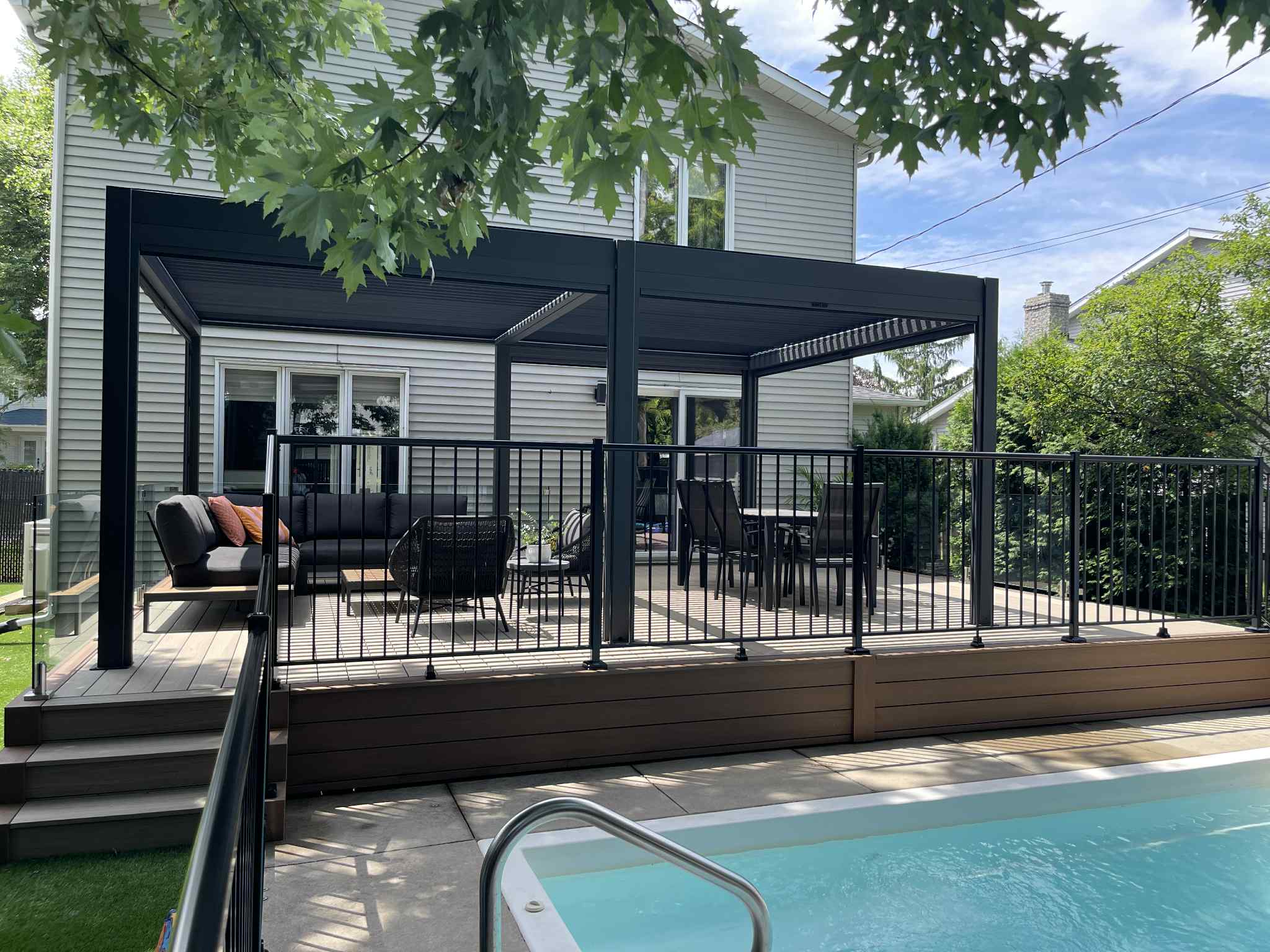 Maison moderne avec terrasse couverte et piscine.