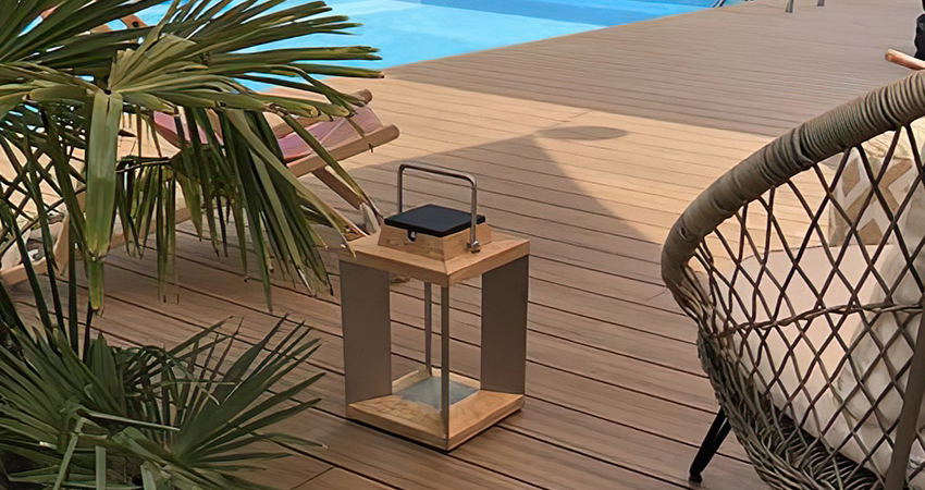 Terrasse en bois avec lanterne et fauteuil.