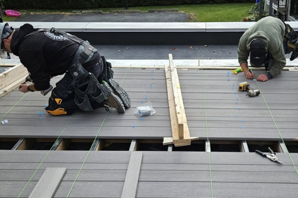 Artisans posant une terrasse en bois composite.