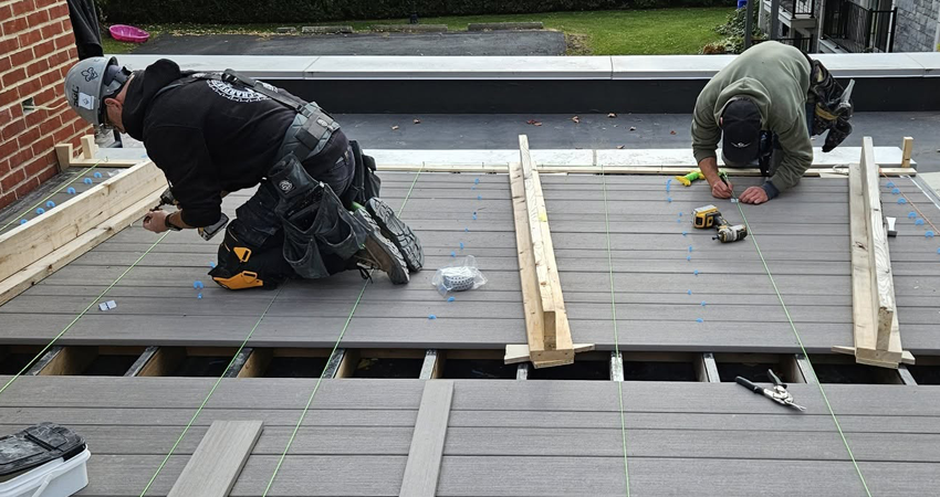 Artisans posant une terrasse en bois composite.